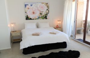 Master suite king sized bed with floral artwork