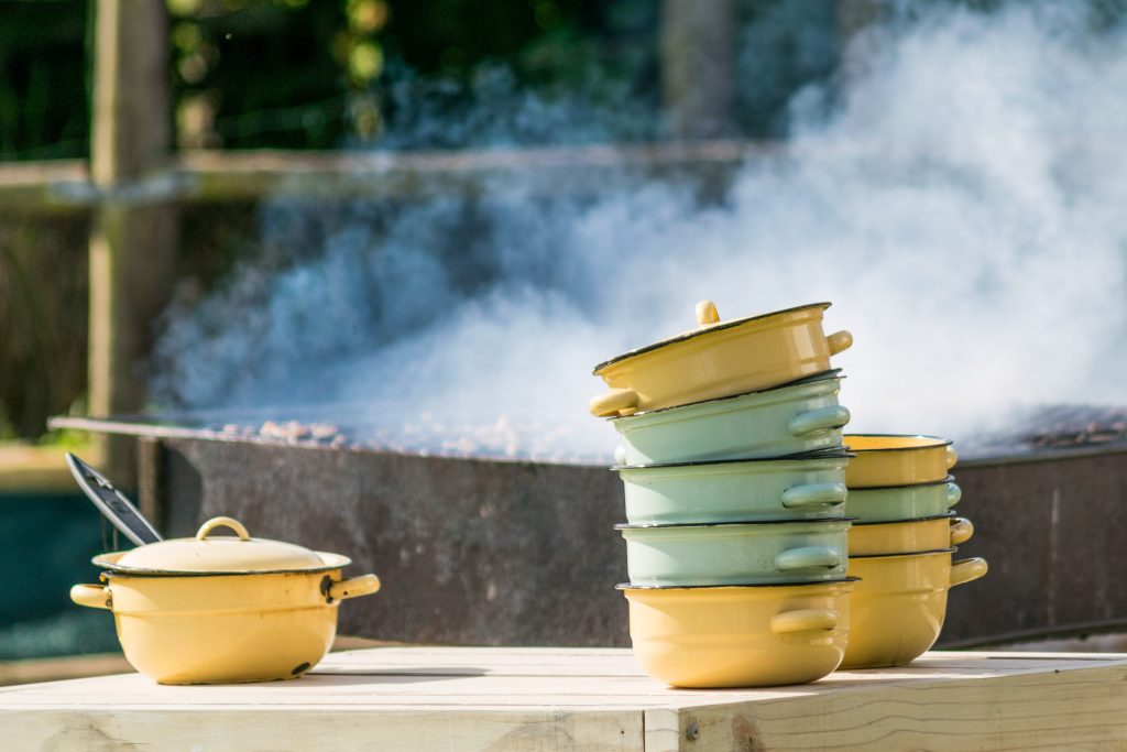 Enamel dishes next to a steaming barbecue